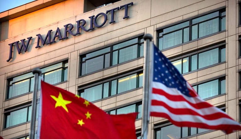 Chinese and American flags fly outside of a JW Marriott hotel in Beijing. The Marriot hotel chain apologized Thursday to China's government for referring to Tibet and self-ruled Taiwan as countries in a customer survey that news reports said Chinese police investigated as a possible crime.