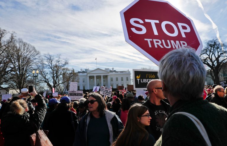 Women's March demonstrators walk past the White House in Washington, Saturday, Jan. 20, 2018.