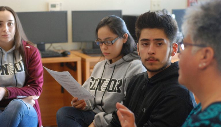 In this Jan. 18, 2018, photo, high school seniors John King, second from right, Ashley Zapata, second from left, and Felicity Sealy, left, listen as English and college-preparation teacher Rhonda Gardner leads a discussion about how to adjust to the academic, financial and social pressures of collegiate life on Thursday, Jan. 18, 2018, in Santa Fe, N.M. 