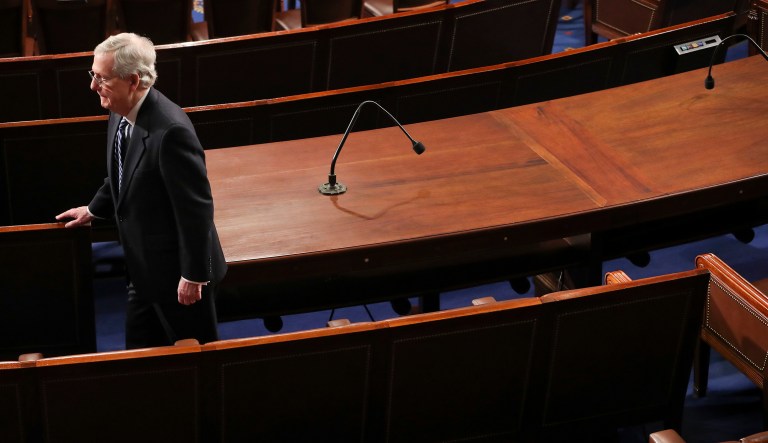 Senate Majority Leader Mitch McConnell of Ky., walks down an empty aisle after attending President Donald Trump's address to a joint session of Congress on Capitol Hill in Washington, Tuesday, Jan. 30, 2018.