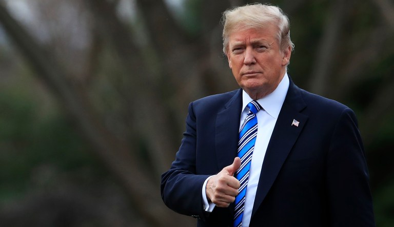 President Trump flashes a thumbs up as he leaves the White House in Washington.