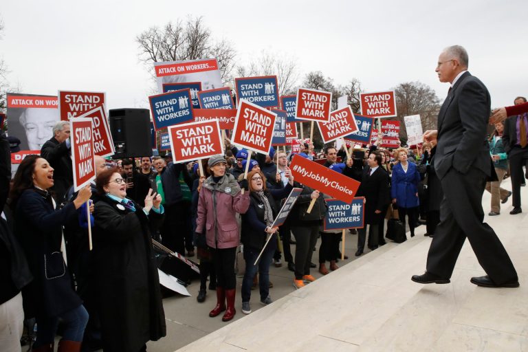 Supporters of Illinois government employee Mark Janus cheer as he walks to thank them, outside the Supreme Court, Monday, Feb. 26, 2018, in Washington. The Supreme Court takes up a challenge Monday in a case that could deal a painful financial blow to organized labor. The court is considering a challenge to an Illinois law that allows unions representing government employees to collect fees from workers who choose not to join.
