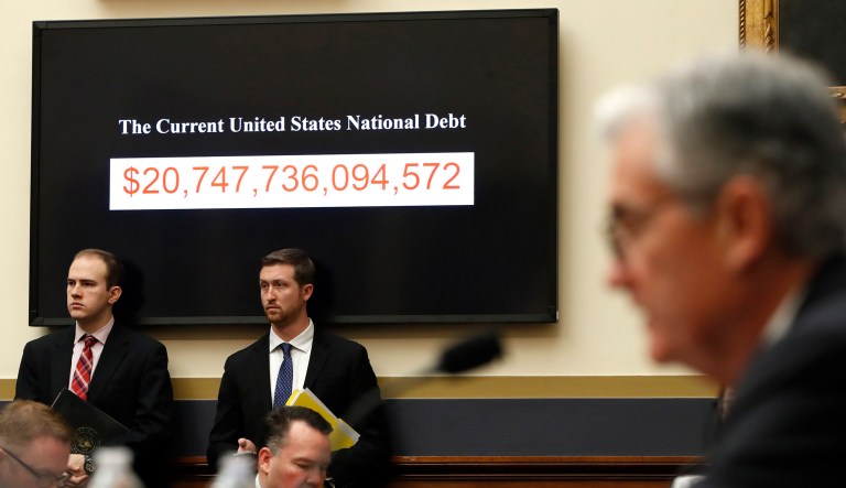The National debt is shown behind Federal Reserve Chairman Jerome Powell as he testifies on the semiannual monetary policy report to the House Financial Services Committee, Tuesday, Feb. 27, 2018, in Washington.