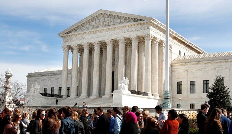 People wait in line to enter the Supreme Court in Washington. 