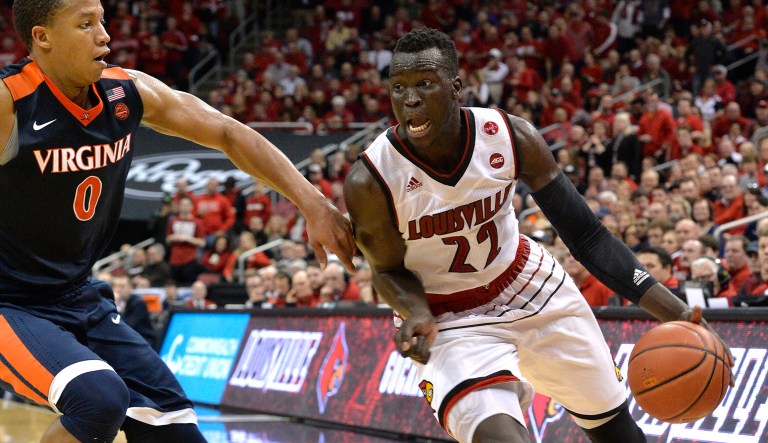 Louisville forward Deng Adel (22) drives past the defense of Virginia guard Devon Hall (0) during the second half of an NCAA college basketball game, Thursday, March 1, 2018, in Louisville, Ky. 