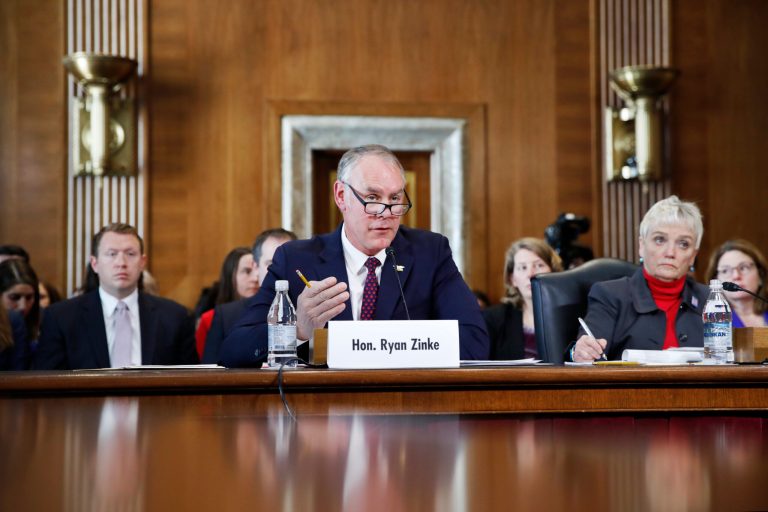 Interior Secretary Ryan Zinke testifies before the Senate Committee on Energy and Natural Resources during a committee hearing on the President's Budget Request for Fiscal Year 2019, Tuesday, March 13, 2018, on Capitol Hill in Washington. At right is Olivia Barton Ferriter, with the Interior Department.