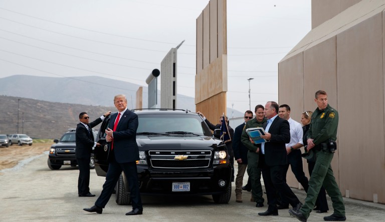 President Trump walks as he reviews border wall prototypes in San Diego. 
