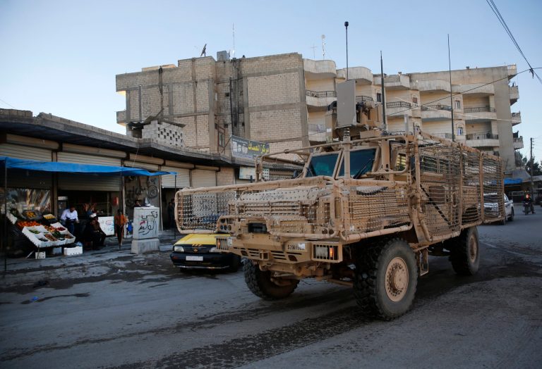 A vehicle of U.S. troops passes on a street, in Manbij town, north Syria, on Saturday.