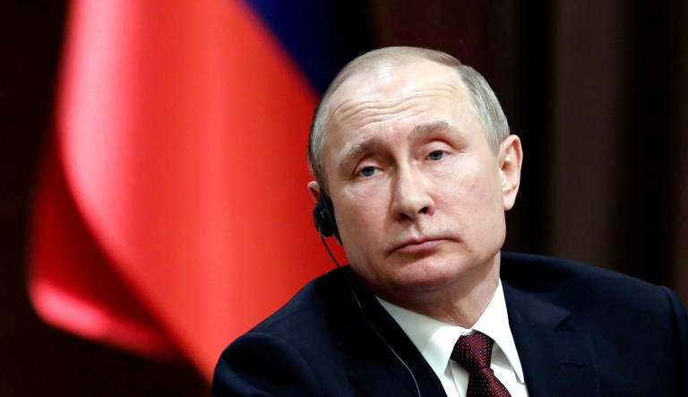 Russia's President Vladimir Putin listens during a news conference.