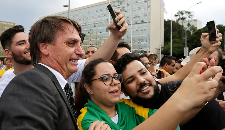 Demonstrators opposed to Brazil's former President Luiz Inacio Lula da Silva have their picture taken with lawmaker Jair Bolsonaro, the main right-wing candidate for the October presidential election, during a protest in Brasilia, Brazil.