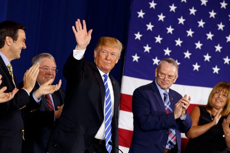 President Donald Trump waves during a roundtable discussion on tax policy, Thursday, April 5, 2018, in White Sulphur Springs, W.Va., with from left, Rep. Evan Jenkins, R-W.Va., West Virginia Attorney General Patrick Morrisey, Trump, CEO of Davis Trust Company Hugh Hitchcock, and assistant head teller at Davis Trust Company Ann Macomber.