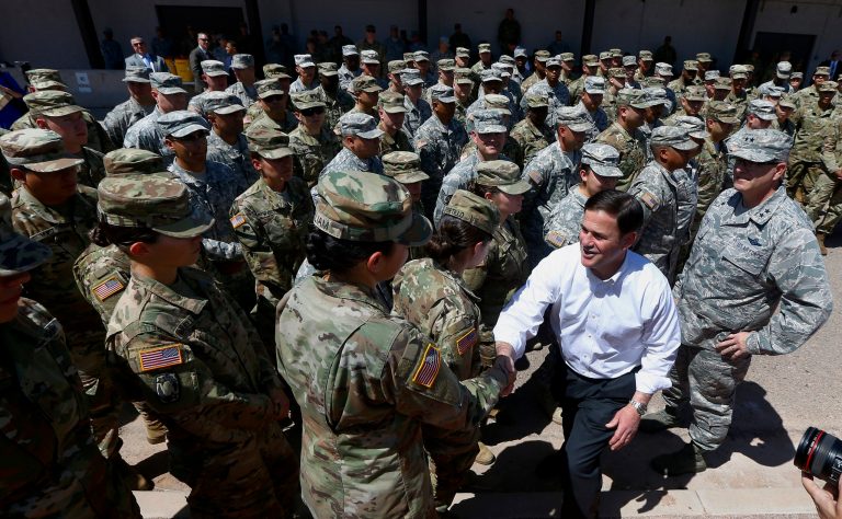 Arizona's Republican Gov. Doug Ducey, front right, meets with Arizona National Guard soldiers prior to their deployment to the Mexico border at the Papago Park Military Reservation on Monday, April 9, 2018, in Phoenix. Ducey told the group of soldiers preparing to deploy from the Phoenix military base that their "mission is about providing manpower and resources" to support agencies on the border and denied that there was a political motive.
