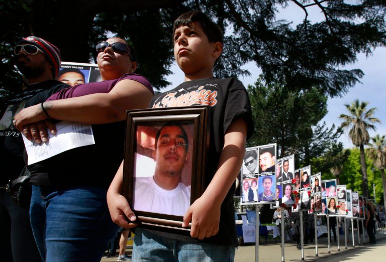 David Gilbert Delsied, Jr., 9, holds a photo of his late step-brother, Juan Carranza III, at a victims' rights rally on Monday in Sacramento, Calif. Carranza III, 20, was stabbed to death in 2015 in Manteca.