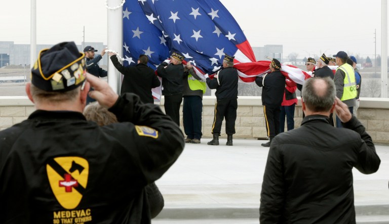 Veteran Ronald Ingram, left, salutes as a large flag is raised at the Omaha National Cemetery during an open house and flag raising ceremony, in Omaha, Neb., Wednesday, April 11, 2018. 