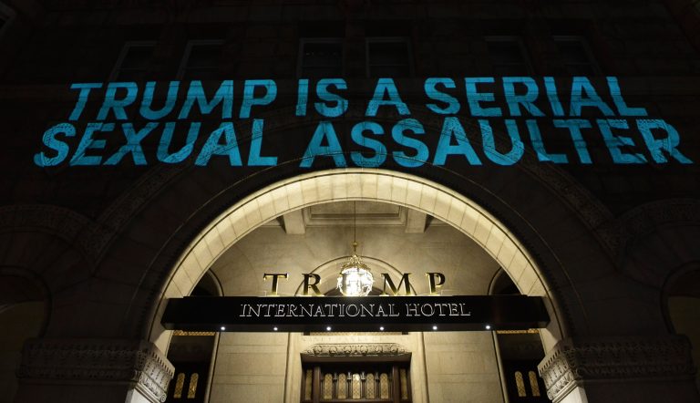 Protesters project a sign on the Trump International Hotel in Washington, Monday, April 16, 2018, to protest President Donald Trump.