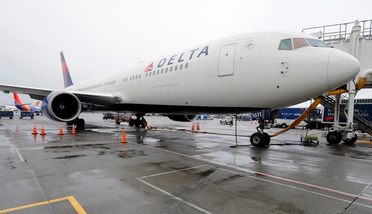 A Delta Air Lines plane sits at a gate.