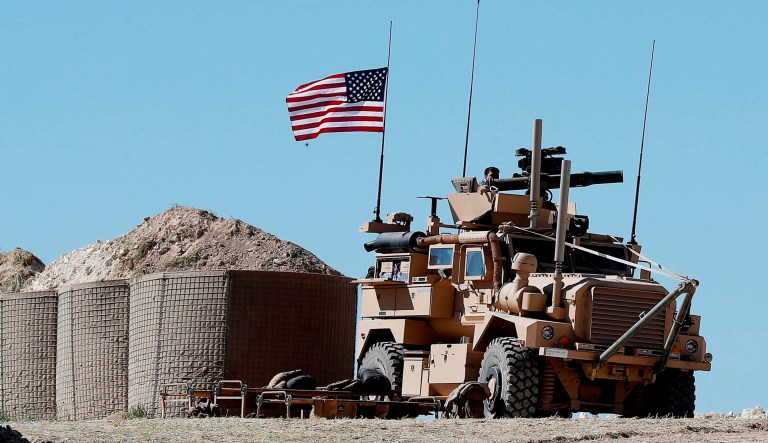 A U.S. soldier sits on an armored vehicle on a newly installed position, near front line between the U.S-backed Syrian Manbij Military Council and the Turkish-backed fighters, in Manbij, north Syria.