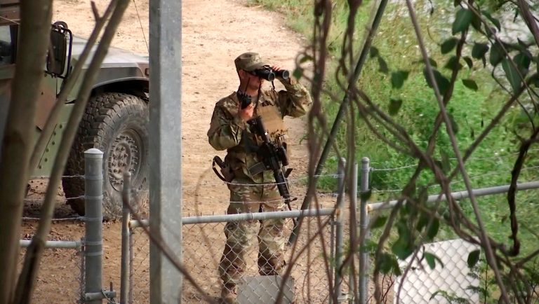 FILE - In this April 10, 2018, file frame from video, a National Guard troop watches over Rio Grande River on the border in Roma, Texas. President Donald Trump has asked governors to deploy thousands of National Guard troops to the border with Mexico, citing a recent surge in people crossing illegally. Apprehensions at the border fell sharply shortly after Trump took office last year but they have gradually increased in recent months. Texas Gov. Greg Abbott, who is running for re-election this year, has eagerly complied with Trump's request, dispatching hundreds of guard members and saying that the Texas contribution could reach 1,400 or more. 