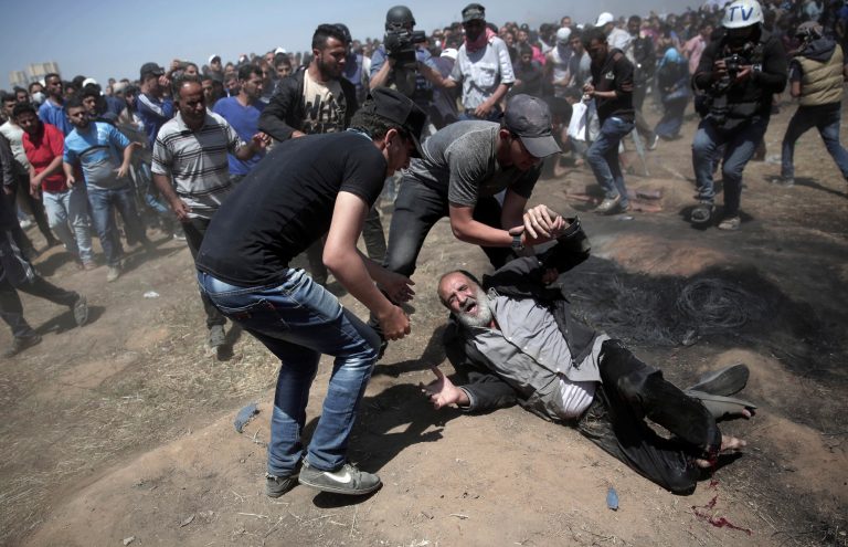 An elderly Palestinian man falls on the ground after being shot by Israeli troops during a deadly protest at the Gaza Strip's border with Israel, east of Khan Younis, Gaza Strip, Monday, May 14, 2018. Thousands of Palestinians are protesting near Gaza's border with Israel, as Israel celebrates the inauguration of a new U.S. Embassy in contested Jerusalem. 