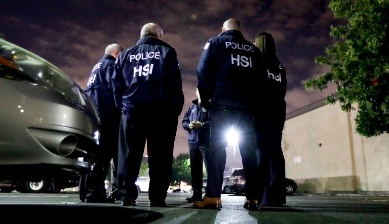 In this Jan. 10, 2018, file photo U.S. Immigration and Customs Enforcement agents gather before serving a employment audit notice at a 7-Eleven convenience store in Los Angeles.