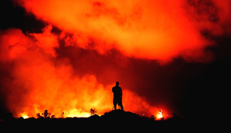 Peter Vance, 24, photographs lava erupting in the Leilani Estates subdivision near Pahoa, Hawaii. Hawaii residents covered their faces with masks after a volcano menacing the Big Island for weeks exploded, sending a mixture of pulverized rock, glass, and crystal into the air in its strongest eruption of sandlike ash in days.