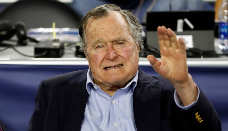 Former U.S. President George H. W. Bush waves after he arrives at an event.