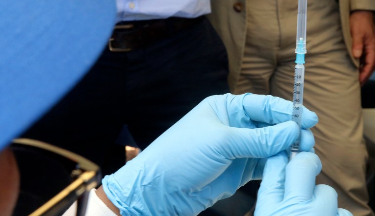 A health worker prepares an Ebola vaccine to administer to health workers during a vaccination campaign in Mbandaka, Congo Monday, May 21, 2018. Congo's health minister says a nurse has died from Ebola in Bikoro, the rural northwestern town where the outbreak began, as the country begins a vaccination campaign. 