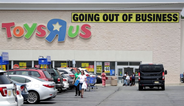 Customers walk back to their vehicles after shopping at a Toys R Us store. 