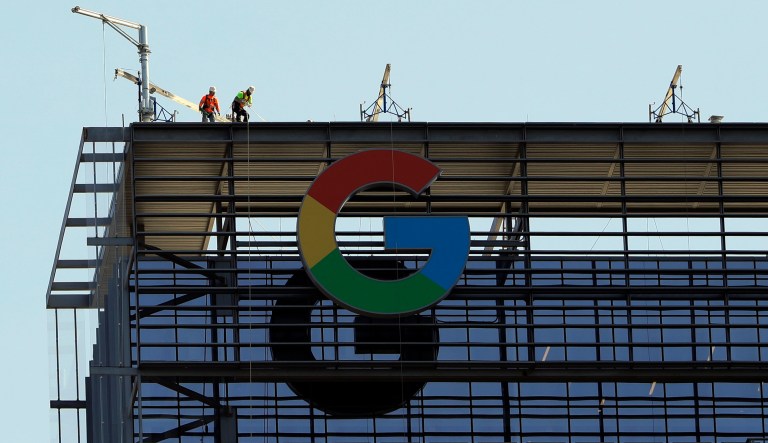 Men work atop a 29-story building nicknamed "the Google building," Wednesday, June 6, 2018, in Austin, Texas. Google leases about 200,000 square feet in the building.