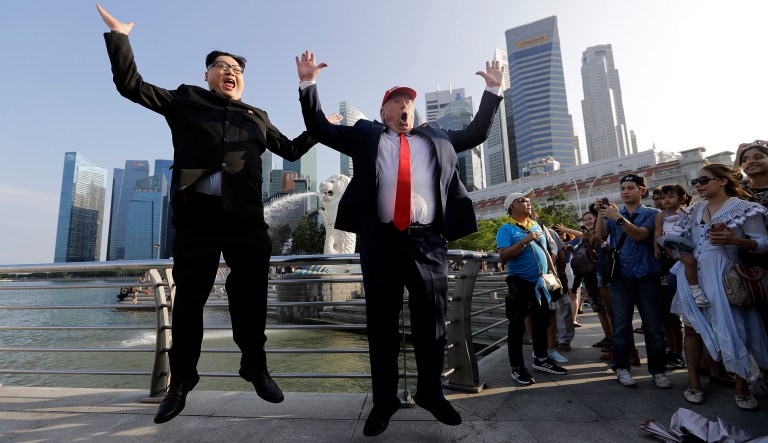 Kim Jong Un and Donald Trump impersonators, Howard X, left, and Dennis Alan, second left, pose for photographs during their visit to the Merlion Park, a popular tourist destination in Singapore on Friday.
