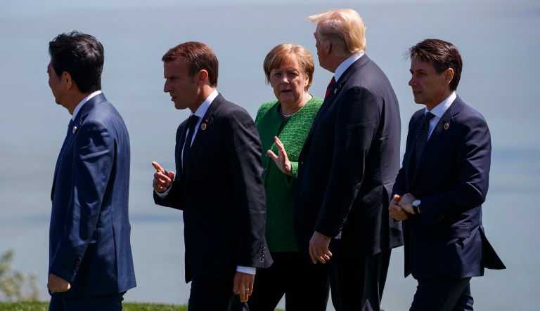 President Trump talks with German Chancellor Angela Merkel after the "family photo" during the G-7 summit on Friday in Charlevoix, Canada. From left, Japanese Prime Minister Shinzo Abe, French President Emmanuel Macron, Merkel, Trump, and Italian Prime Minister Giuseppe Conte.