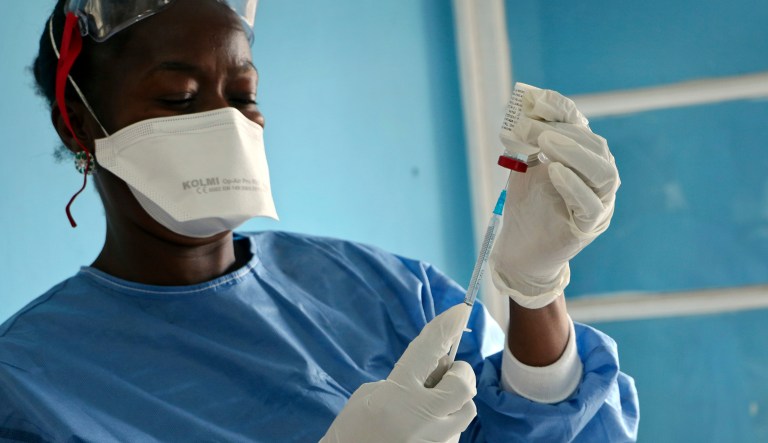 In this photo taken Wednesday, May 30, 2018, a healthcare worker from the World Health Organization prepares vaccines to give to front line aid workers, in Mbandaka, Congo. For the first time since the Ebola virus was identified more than 40 years ago, a vaccine has been dispatched to front line health workers in an attempt to combat the epidemic from the onset.