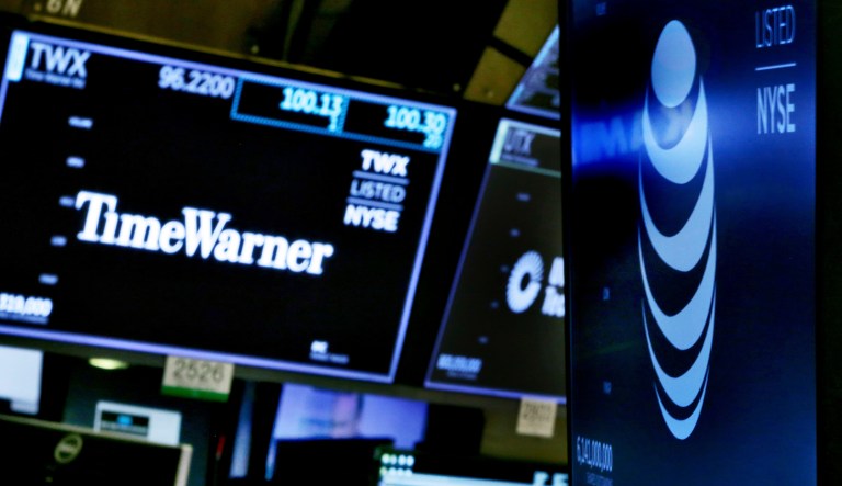 The logos for Time Warner and AT&T appear above alternate trading posts on the floor of the New York Stock Exchange on June 13, 2018.