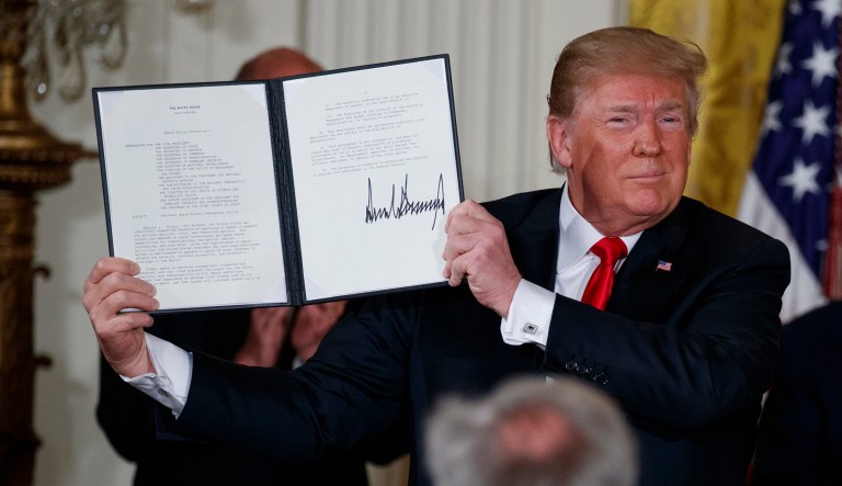 President Trump shows off a "Space Policy Directive" after signing it during a meeting of the National Space Council in the East Room of the White House on Monday in Washington.