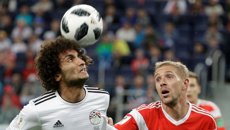 Russia's Yuri Gazinsky, right, challenges for the ball with Egypt's Amr Warda during the group A match between Russia and Egypt at the 2018 soccer World Cup in the St. Petersburg stadium.