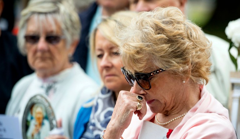 Ann Reeves, daughter of Elsie Devine who died at Gosport War Memorial Hospital, stands with families of other victims outside Portsmouth Cathedral in the United Kingdom on Wednesday after the disclosure of the Gosport Independent Panel's report.