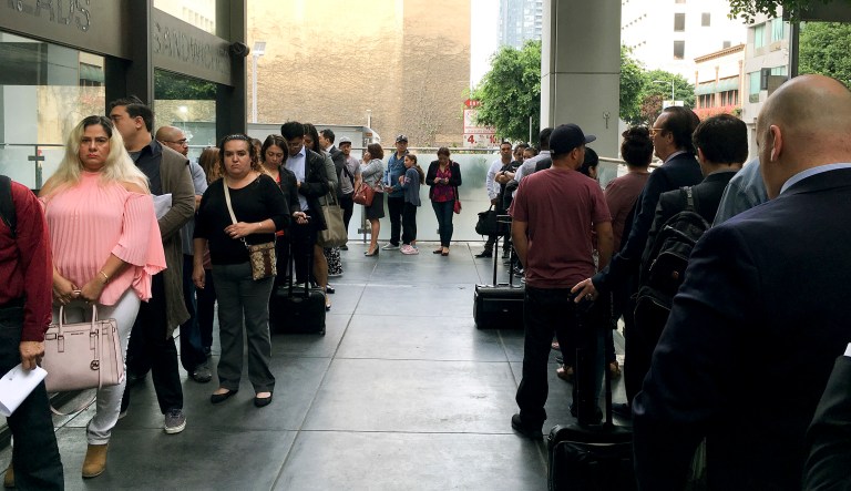 In this Tuesday, June 19, 2018, photo, immigrants awaiting deportation hearings line up outside the building that houses the immigration courts in Los Angeles.