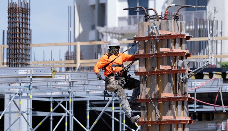 A construction worker works on the site of Gables Station, a mixed use project featuring apartments, retail, a hotel and cafes, in Coral Gables, Fla.