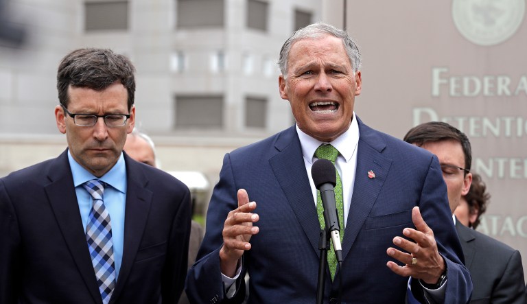 Washington Gov. Jay Inslee, right, speaks as Attorney General Bob Ferguson looks on at a news conference announcing a lawsuit against the Trump administration over a policy of separating immigrant families illegally entering the United States, in front of the Federal Detention Center Thursday, June 21, 2018, in SeaTac, Wash. Ferguson made the announcement outside the federal prison south of Seattle, where about 200 immigration detainees have been transferred â including dozens of women separated from their children under the administration's "zero tolerance" policy.