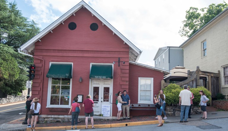 Passersby gather to take photos in front of the Red Hen Restaurant in Lexington, Va. The restaurant has become internationally famous since ousting Sarah Sanders in June.