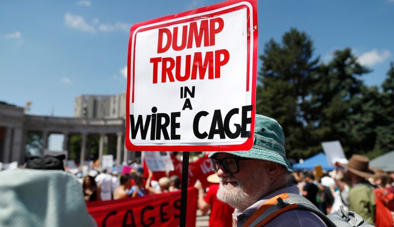 An unidentified protester holds up a sign during an immigration rally and protest in Civic Center Park on June 30, 2018, in downtown Denver.