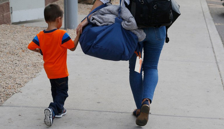 Three-year-old Jose Jr., from Honduras, is helped by a representative of the Southern Poverty Law Center as he is reunited with his father on July 10, 2018, in Phoenix.