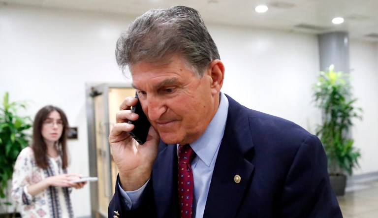 Sen. Joe Manchin, D-W.Va., walks with his phone on Capitol Hill in Washington, D.C.