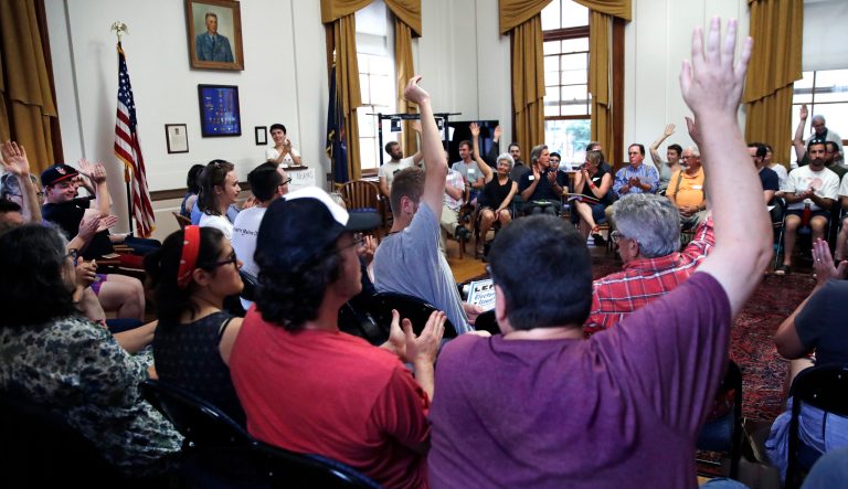 First time guests raise their hands during introductions during a meeting with members of the Southern Maine Democratic Socialists of America in Portland, Maine, Monday, July 16, 2018. 
