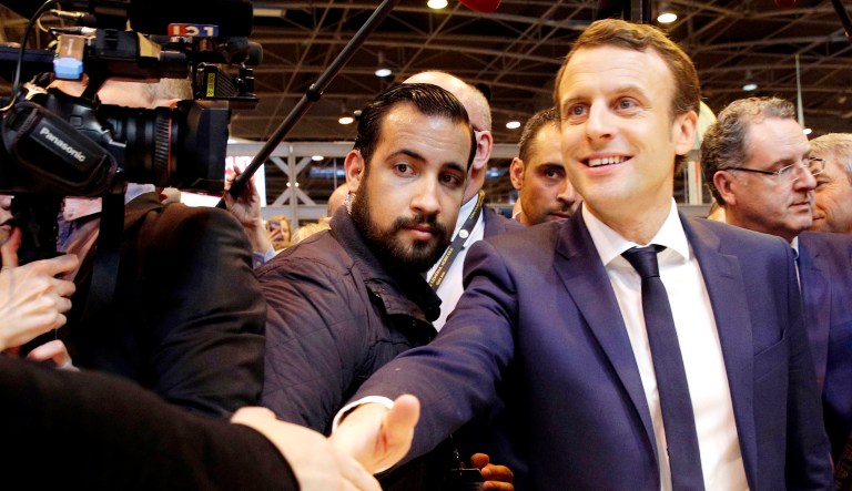 In this March 1, 2017 file picture, then-French presidential candidate Emmanuel Macron, right, flanked by his bodyguard, Alexandre Benalla, center, attends an event.