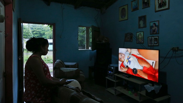 Adalicia Montecinos watches a video at her home in La Libertad, Honduras, of her son Johan Bueso Montecinos who was separated from his father at the Texas border.