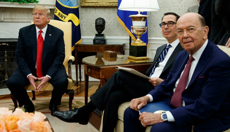 President Trump sits with Secretary of Commerce Wilbur Ross and Treasury Secretary Steve Mnuchin during a meeting in the Oval Office of the White House on July 25, 2018.