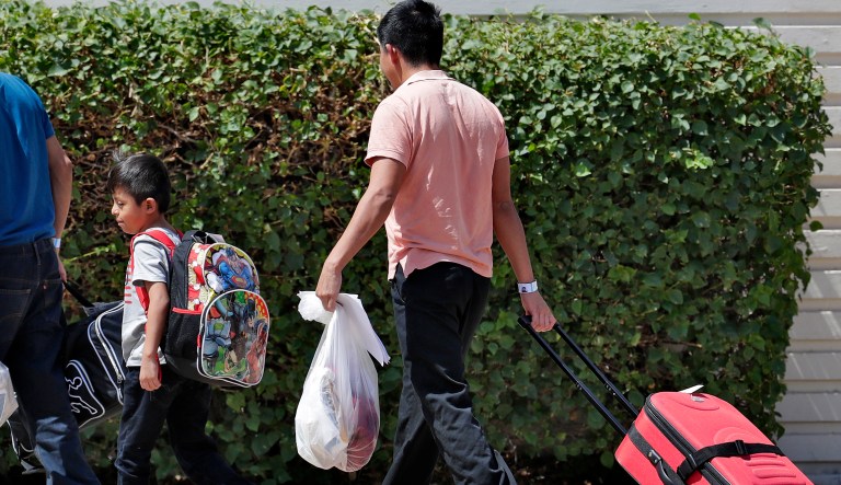 A child and a man arrive at Lutheran Social Services, Thursday, July 26, 2018, in Phoenix. Lutheran Social Services stated they were expecting 75-100 reunited families separated at the border when apprehended entering the United States to come through their facility. 