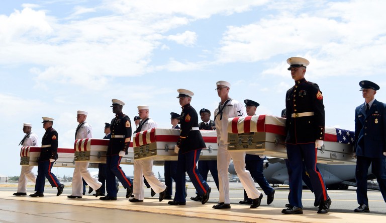 Military members carry transfer cases from a C-17 at a ceremony marking the arrival of the remains believed to be of American service members who fell in the Korean War at Joint Base Pearl Harbor-Hickam in Hawaii. 