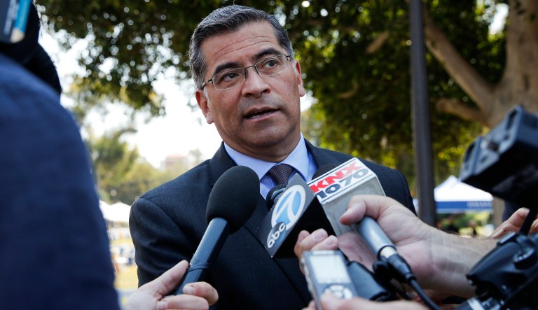 California Attorney General Xavier Becerra talks to reporters after a news conference at University of California, Los Angeles Thursday, Aug. 2, 2018. Becerra spoke about his efforts to fight the Trump administration's proposal to weaken car efficiency fuel standards. 